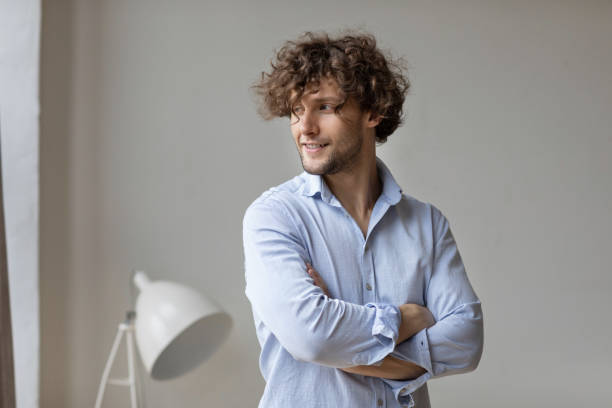 Happy young smiling curly haired guy. Businessman at home