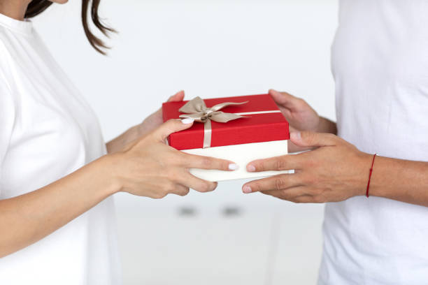 istock Close up man hands give wrapped gift box woman. 1298991965