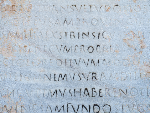 The ancient inscription is on the antique column or the wall. Ancient greek language