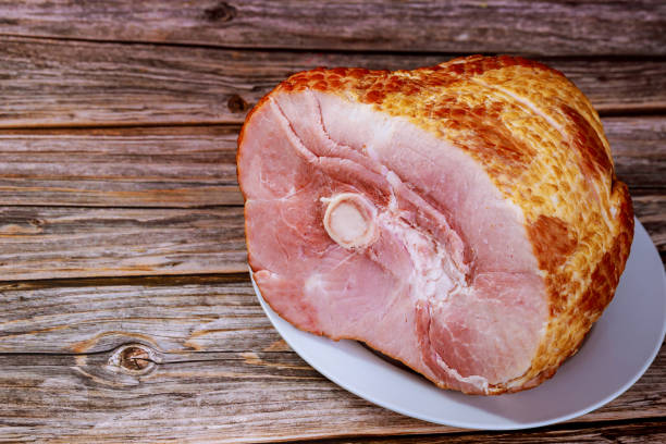 istock Sliced honey smoked ham on wooden table. 1298992574
