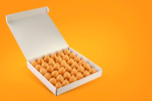 Brazilian snacks A box of deep fried croquettes for delivery isolated in orange background (coxinha de frango) coxinha stock pictures, royalty-free photos & images