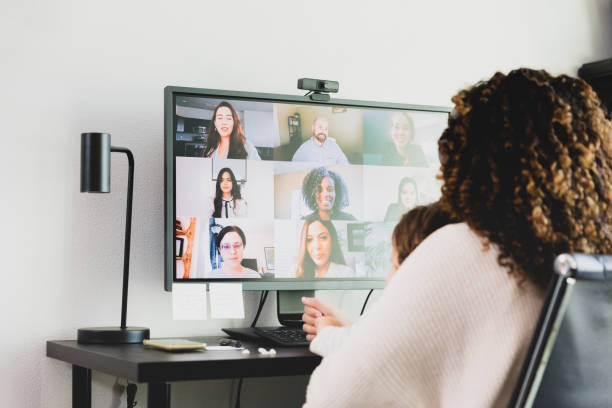 istock Unrecognizable woman video conferences with colleagues while holding baby 1298997600