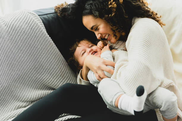 istock Mom snuggles and tickles baby 1298997640