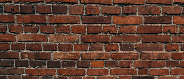 The texture of an old brick wall with natural defects. Scratches, cracks, crevices, chips, dust, roughness, abrasion. Template for design and background.Copy space,banner, wide panorama
