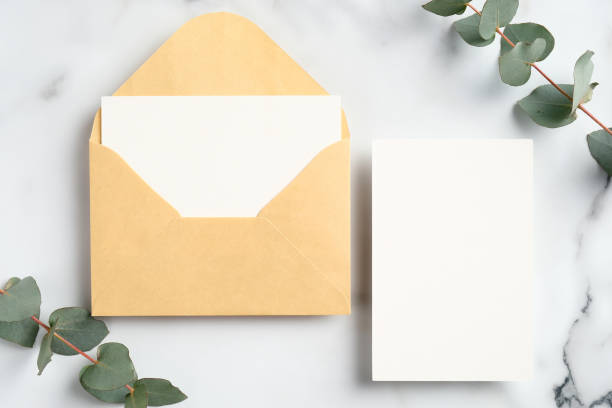 istock Top view wedding invitations and eucalyptus leaves on marble table. Wedding stationery set. 1298998996