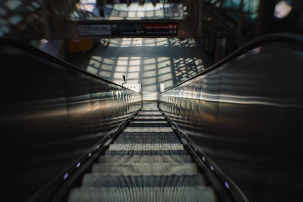 istock View of escalator looking down with shadows and lines from windows 1298999677