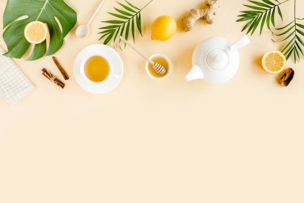istock Herbal tea with mint, ginger, lemon, honey and other herbs on yellow background. Flat lay, top view 1299002598