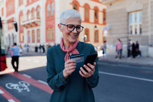 istock Senior Caucasian woman using a smart phone and a credit card 1299003215