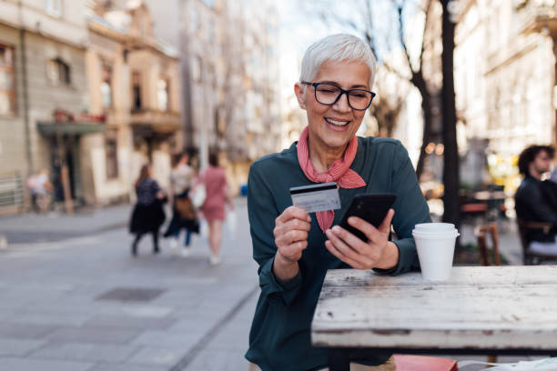 istock Senior Caucasian woman using a smart phone and a credit card 1299003218
