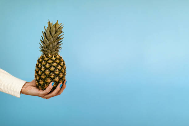 istock Woman holding pineapple 1299004421