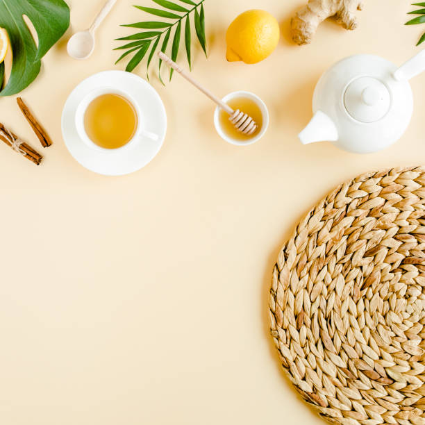 istock Herbal tea with mint, ginger, lemon, honey and other herbs on yellow background. Flat lay, top view 1299004673