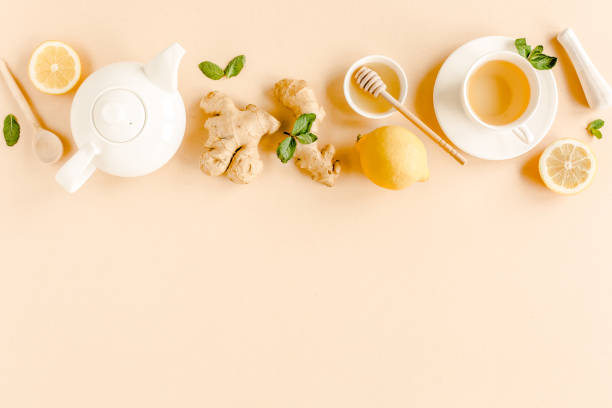 istock Herbal tea with mint, ginger, lemon, honey and other herbs on yellow background. Flat lay, top view 1299005386