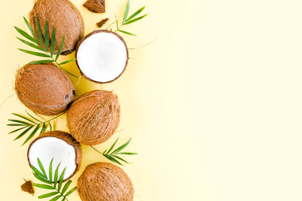 istock Pattern with coconuts and tropical palm leaves on yellow background. Tropical abstract background. Flat lay, top view 1299005787