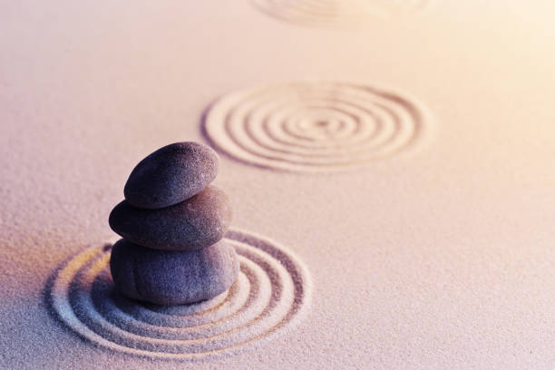 istock Meditation zen garden with stones on sand 1299011366