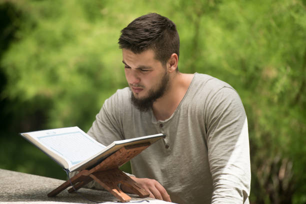 istock Muslim Man Is Reading The Koran In Park 1299011936