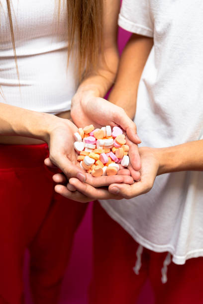 Young woman putting candy heart onto open hand
