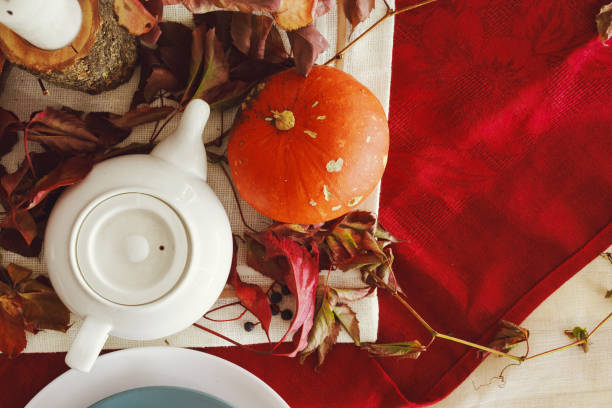 istock Stylish thanksgiving autumn table decor with pumpkin and dried branches 1299015628