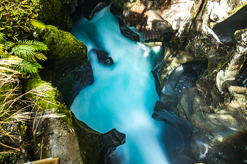 Bright blue ravine, gushing river and flowing water through a rocky canyon