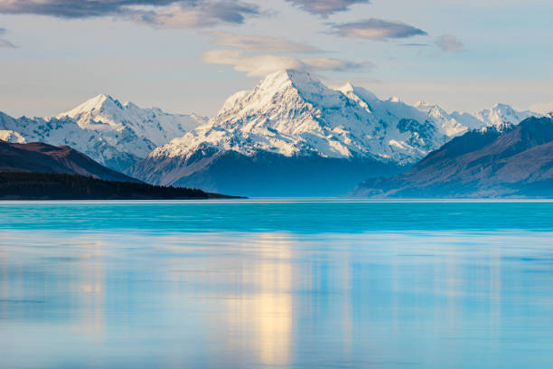 istock Snow covered mountain reflecting off a calm and smooth blue lake 1299017397