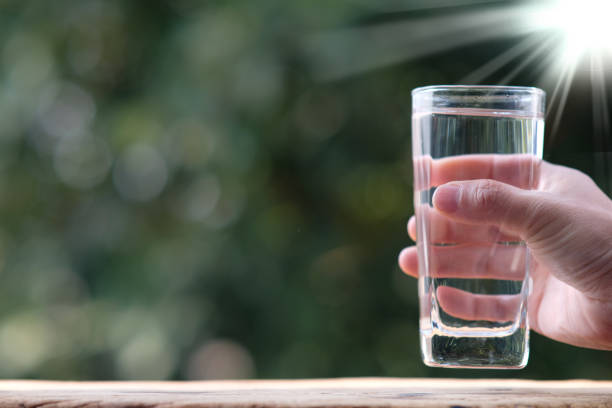istock pouring drinking water on wood table and spec for text 1299018924