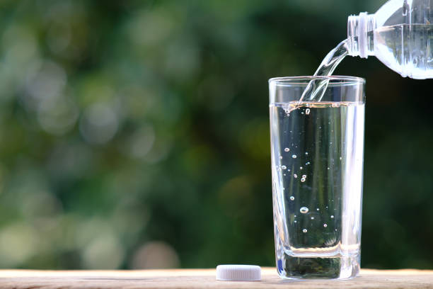 istock pouring drinking water on wood table and spec for text 1299018933