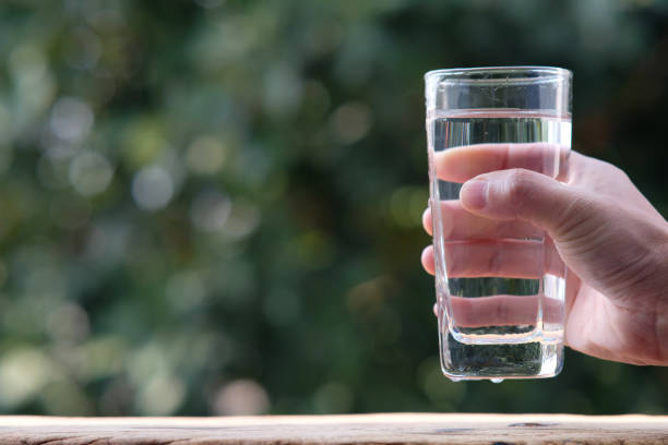 istock pouring drinking water on wood table and spec for text 1299019456