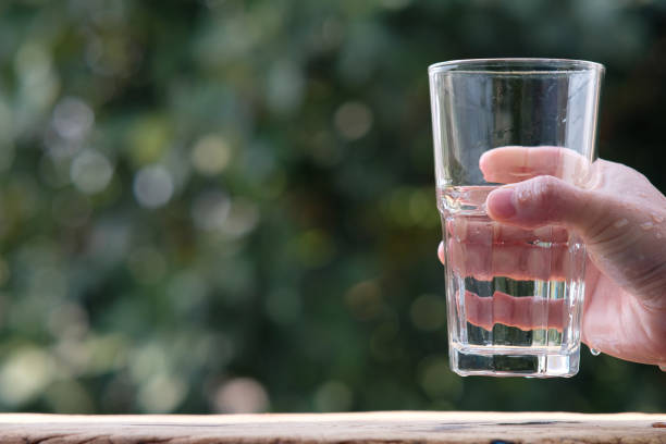 istock pouring drinking water on wood table and spec for text 1299019458
