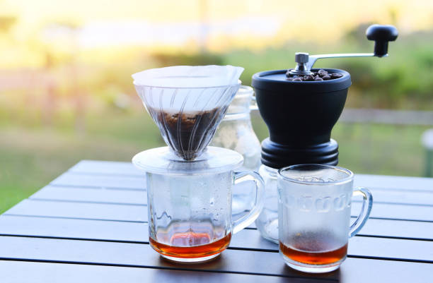 istock make cup hand drip coffee in glass jar on outdoors, drip coffee barista pouring water on filtered brewing. 1299020651
