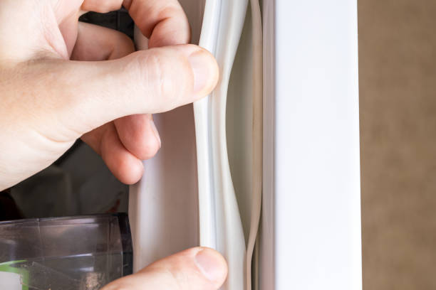 broken refrigerator door seal. appliance repair service concept. replace fridge door sealant or gasket stock photo