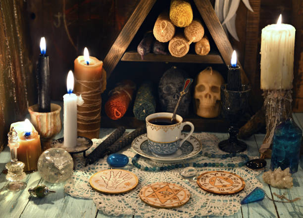 istock Prediction ritual with cup of tea, burning candles and crystals on witch table. 1299029046