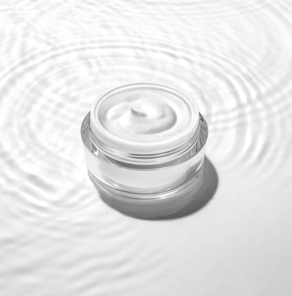 White cosmetic jar on the water surface. Summer water pool fresh concept. stock photo