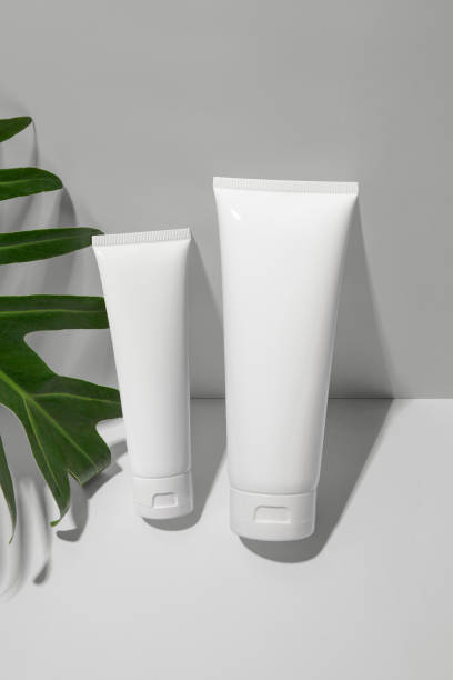 istock White cosmetic tubes with green leaf on white background. Blank label for branding mock-up. Natural beauty product concept. 1299041524