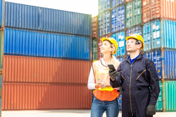 istock Foreman are using mobile phones in the port of loading goods. Foreman control loading containers box from cargo freight ship for import export. 1299043159