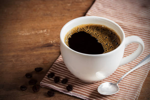 나무 테이블에 커피 컵과 커피 콩 - caffeine free 뉴스 사진 이미지