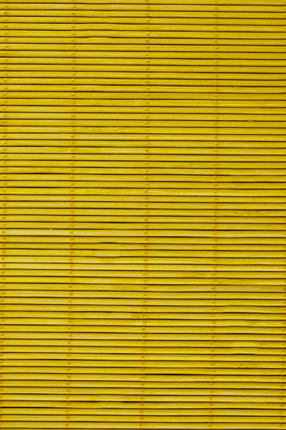 istock Wooden blinds on the mustard-colored windows.Texture or background 1299044055
