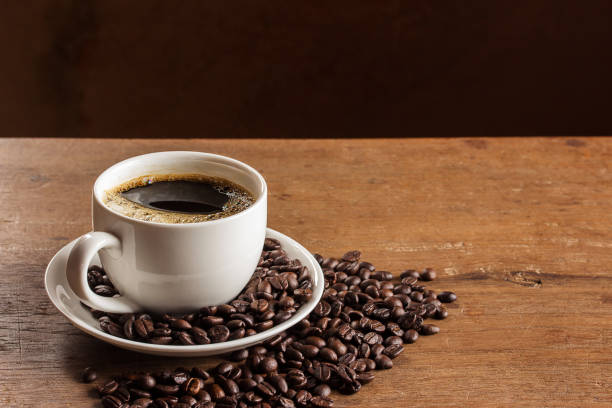 istock Coffee cup and coffee beans on wooden table 1299044924