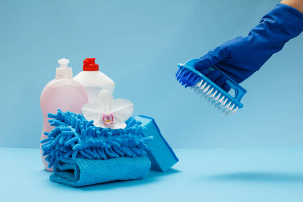 istock Woman's hand in a protective glove with a brush on the blue background. 1299045941