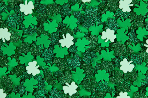 istock Shamrock confetti texture background with green and white lucky clovers 1299047956