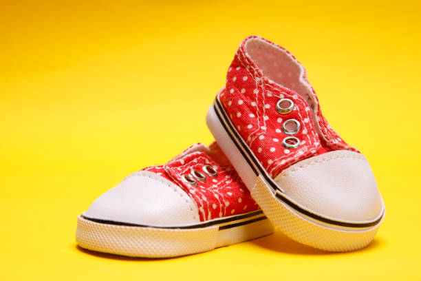 istock red children's boots with white polka dots on a yellow background 1299048050