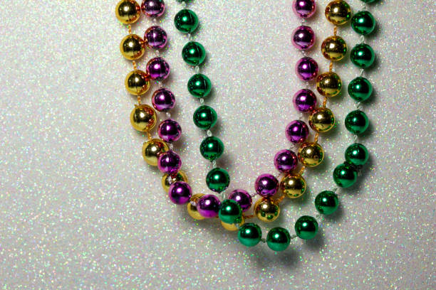 istock Macro abstract texture background of Mardi Gras beads on a white glitter background 1299048289