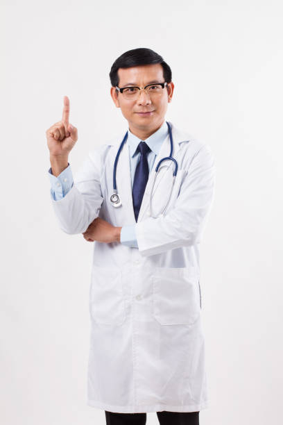 istock confident asian male doctor pointing up 1 finger 1299050585
