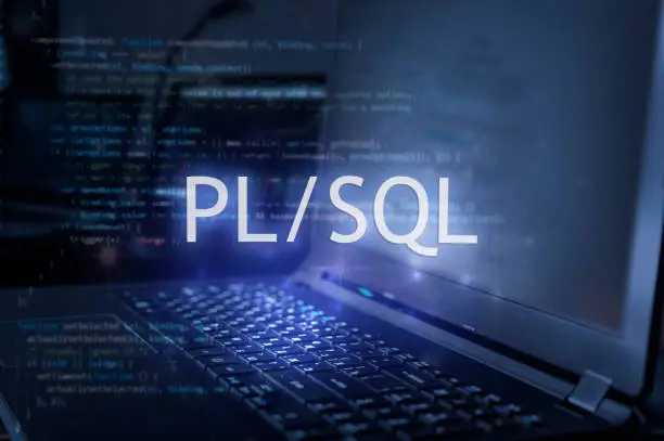 Photo of PL/SQL inscription against laptop and code background. Learn pl/sql programming language, computer courses, training.