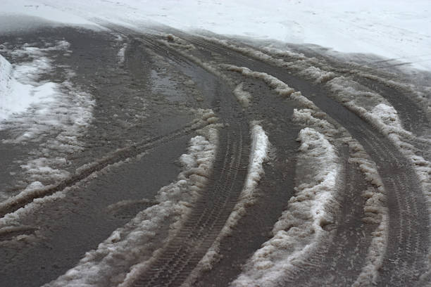 wet tire tracks on a winter road in a thaw
