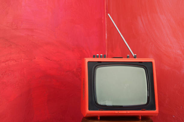 istock Old Fashioned Red TV Box On Red Colored Wall 1299053856