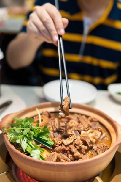 istock Chopsticks picking up a piece of Beef Brisket from hot pot 1299053980