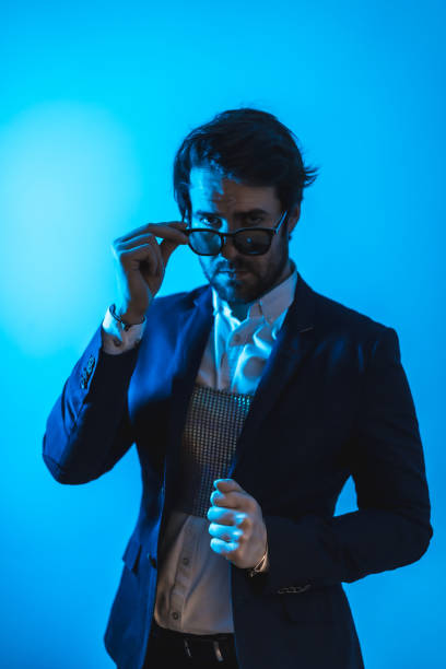 istock Studio lifestyle, a handsome young Caucasian man in a session with elegant clothes and sunglasses, with neon blue light 1299054977