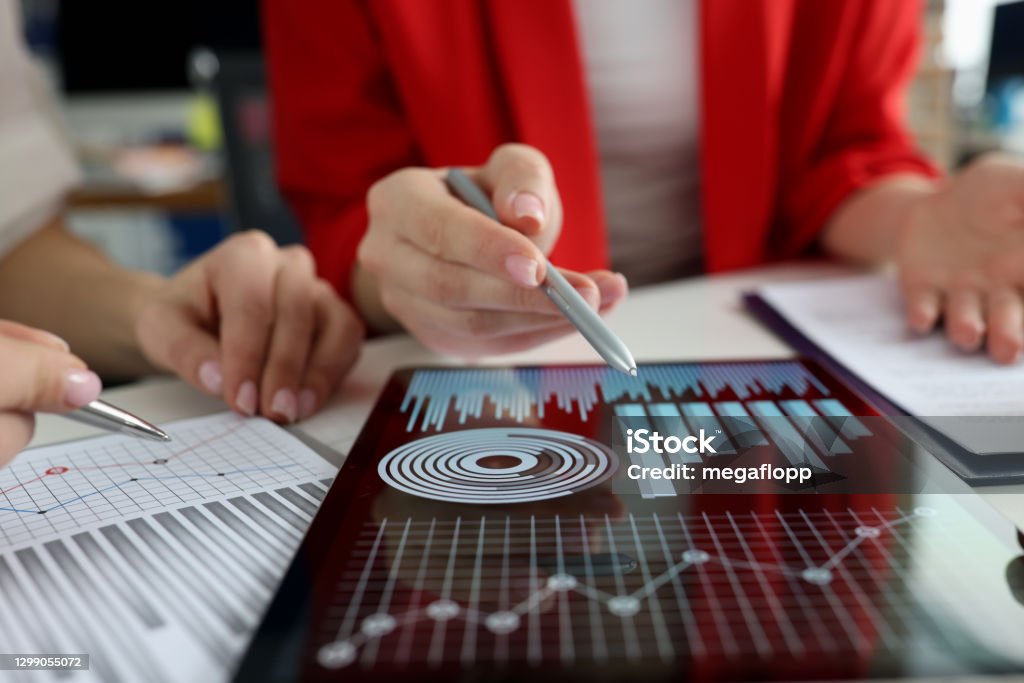 Affärskvinnor som studerar diagram och diagram på närbild av digitala surfplattor - Royaltyfri Data Bildbanksbilder