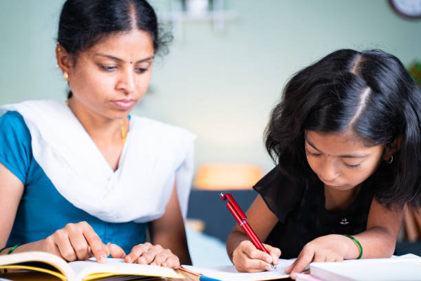 istock selective focus on kid Mother helping her kid for doing school homework - concept of parenthood, assistance, relationship and bonding. 1299055252