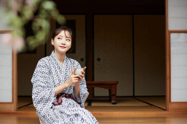 a young asian woman is relaxing at japanese traditional inn - fonte térmica imagens e fotografias de stock