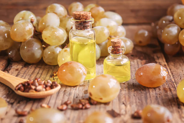 istock Grape seed oil in glass jar on wooden background. Selective focus 1299059200